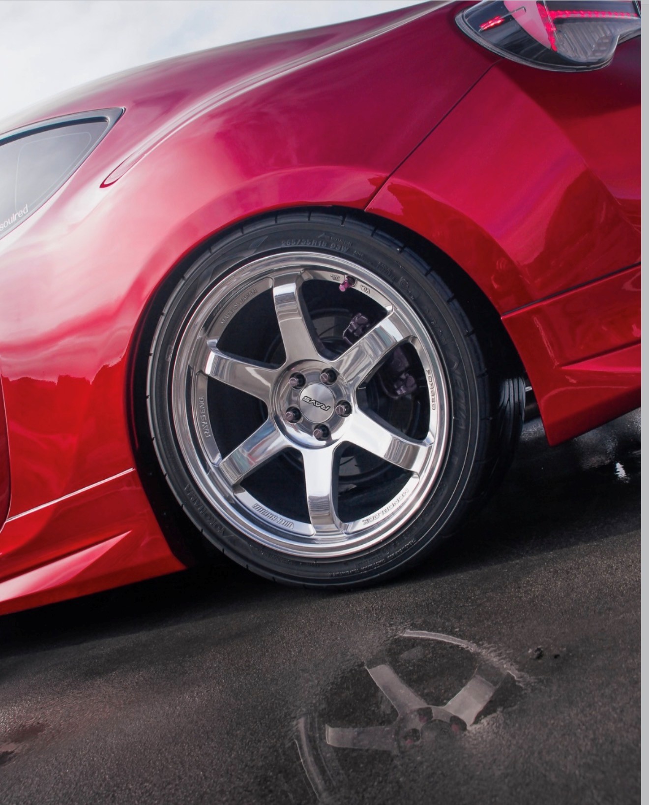 Close-up of a polished Rays wheel on a red Toyota 86