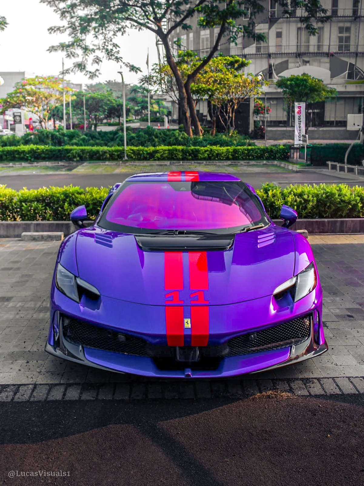 Purple supercar with red racing stripes on a tree-lined street