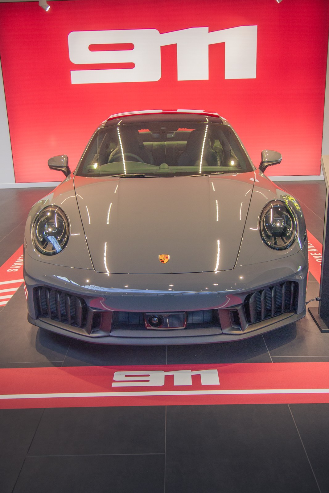 Porsche 911 in a showroom under red lighting