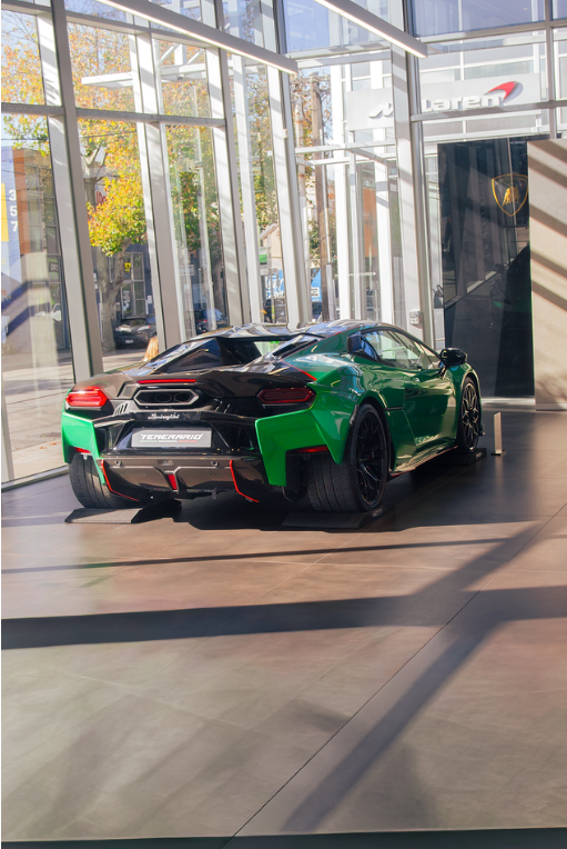 Green Lamborghini Huracan Tecnica in a glass-fronted showroom