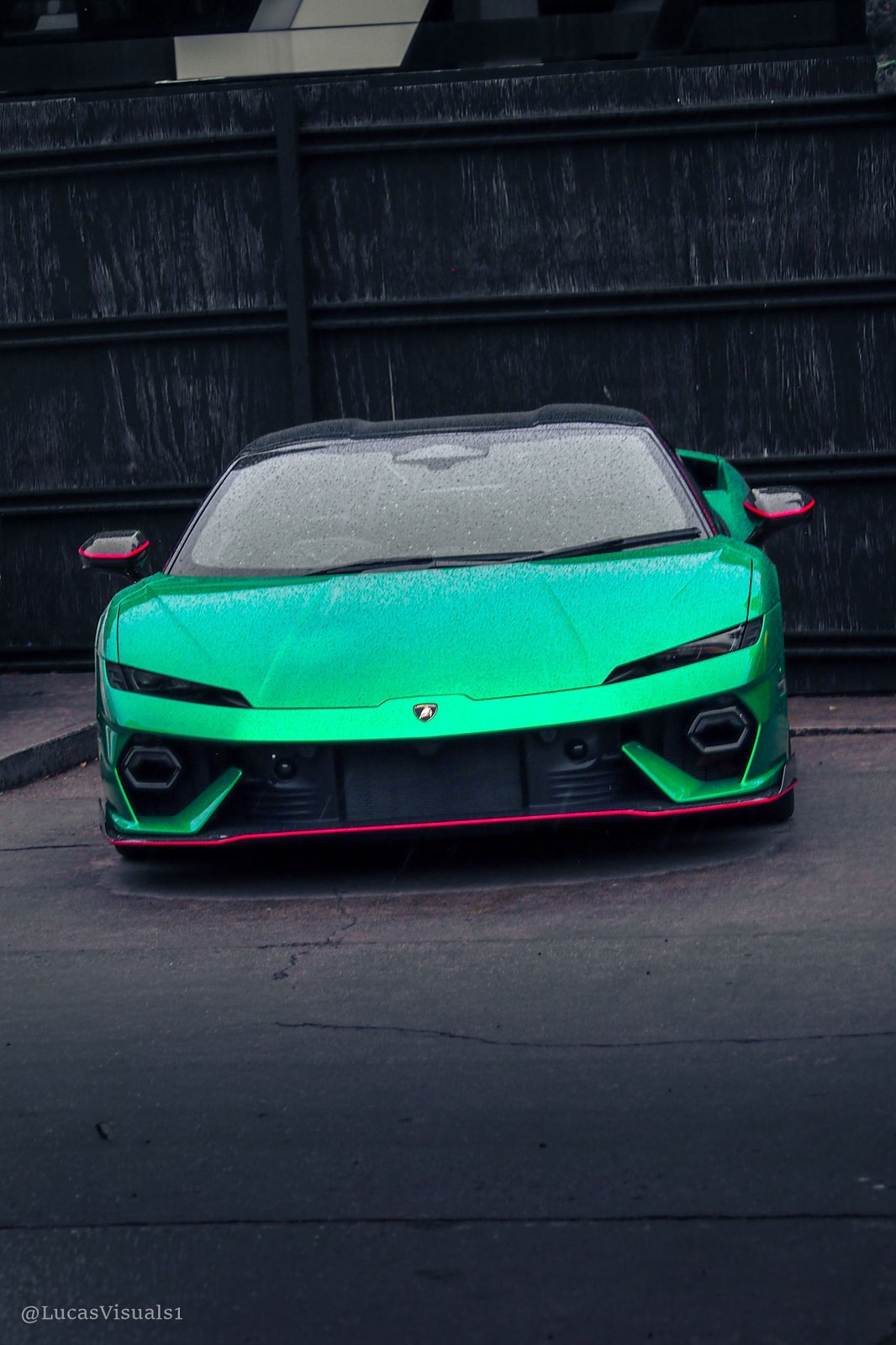 Green Ferrari parked outside a warehouse